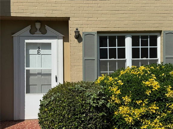 Front view of a house with a white door and double windows.