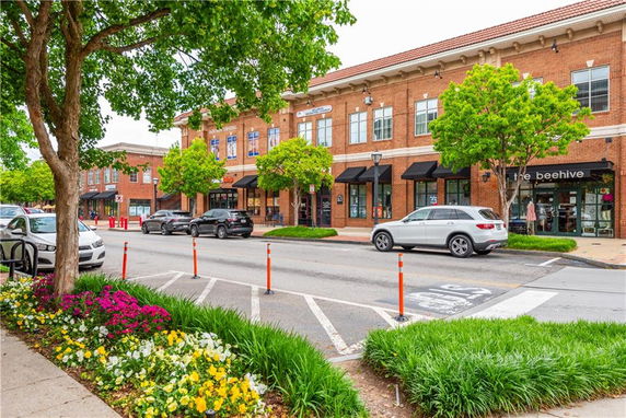 Front view of a two-story commercial building with shops and parking area.