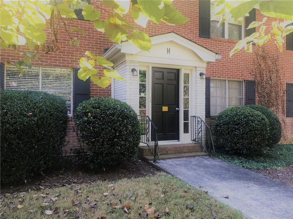 Front view of a brick house with black door and windows.