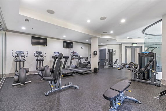 View of a gym area with exercise equipment, including treadmills, ellipticals, and weight machines.