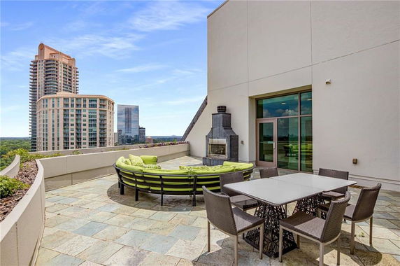 Rooftop terrace with outdoor seating, dining table, and fireplace.