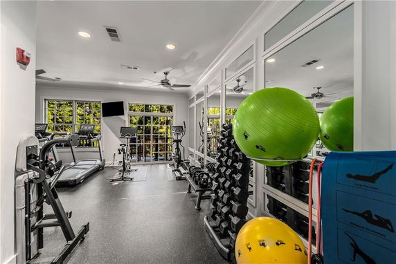 Indoor gym area with exercise equipment, including treadmills and weights.