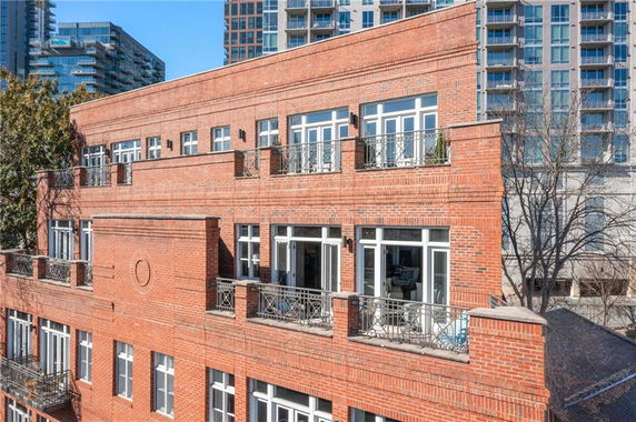 Front view of a multi-story brick building with balconies.