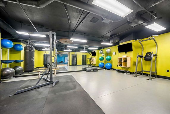 Indoor gym area with exercise equipment and a punching bag.