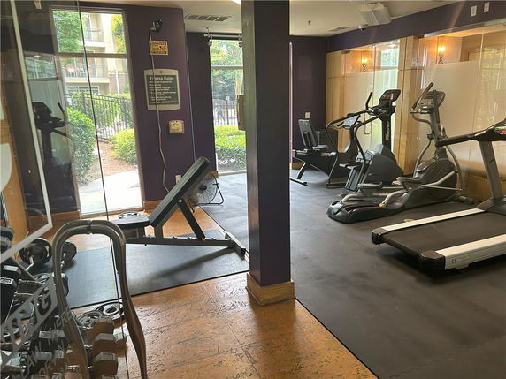 Indoor gym area with exercise equipment including treadmills and weights.
