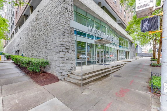 Front view of a building with stone and glass facade featuring a prominent entrance.