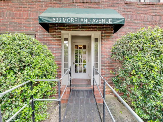 Front view of a brick building entrance with a green awning labeled '633 Moreland Avenue'.