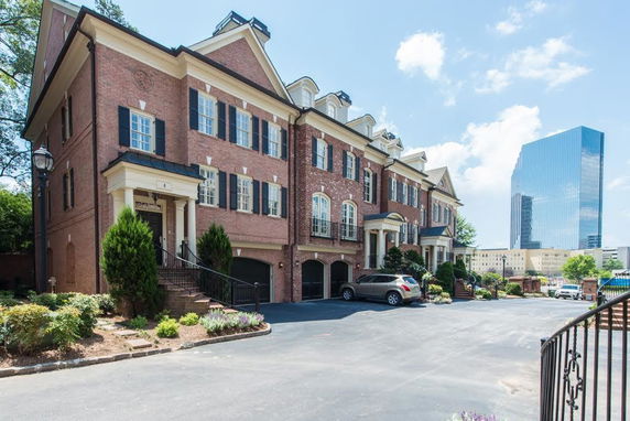 Front view of a multi-story townhouse with brick exterior and garages.