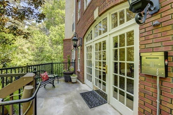 Entrance of a building with large glass doors and a brick facade.