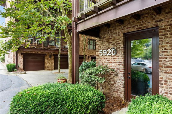 Front view of a brick building with a glass door and garage entrance.