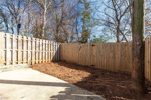 Outdoor fenced area with wooden fencing and a small area of bare ground.