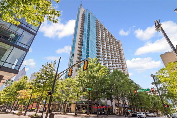 Front view of a high-rise building with glass windows and balconies.