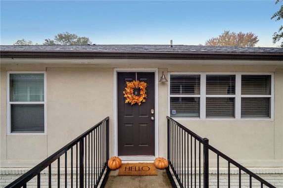 Front view of a house entrance with a door and windows.