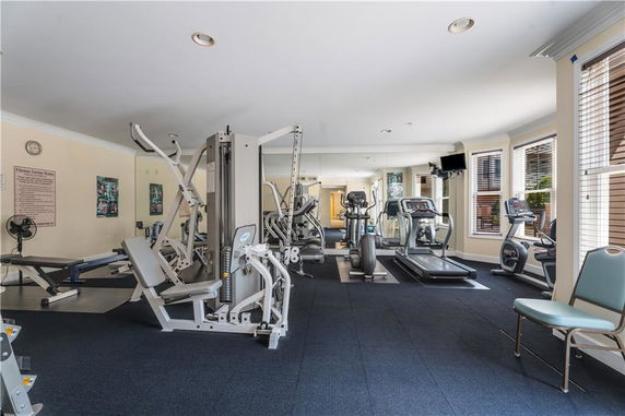 Indoor gym with various exercise equipment and mirrors.