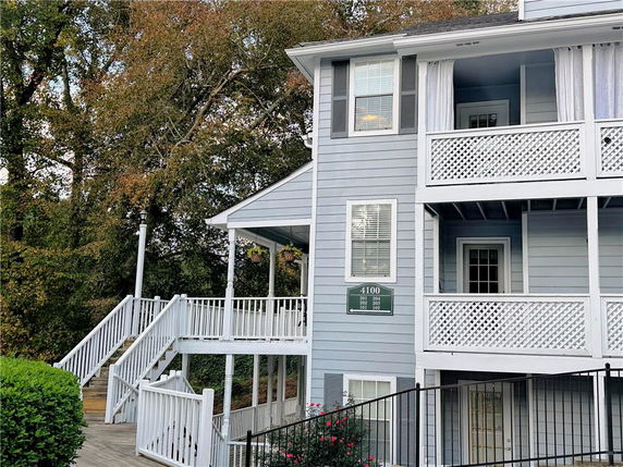 Front view of a multi-story building with balconies and outdoor stairs.