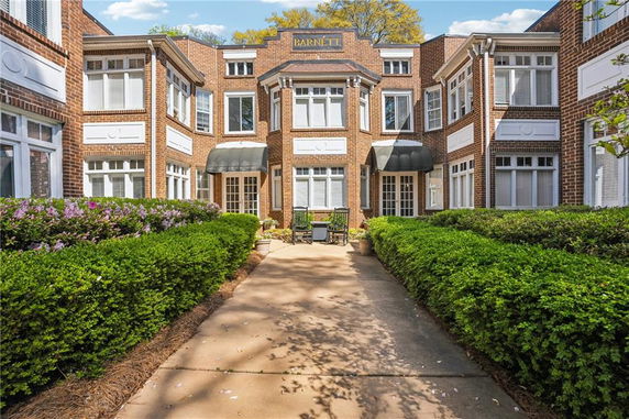 Front view of a multi-story brick building with numerous windows and a central entrance.