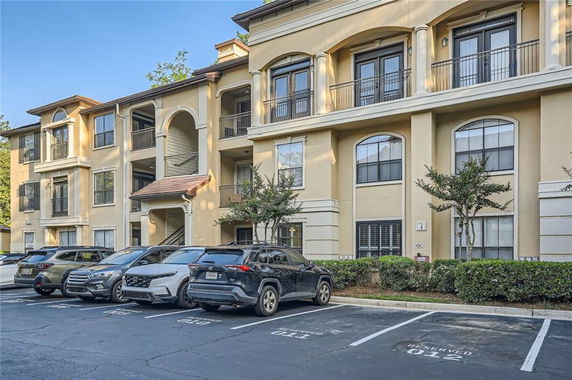 Front view of a multi-story apartment building with reserved parking spaces.