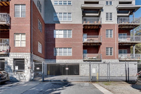 Front view of a multi-story apartment building with brick and concrete facade.