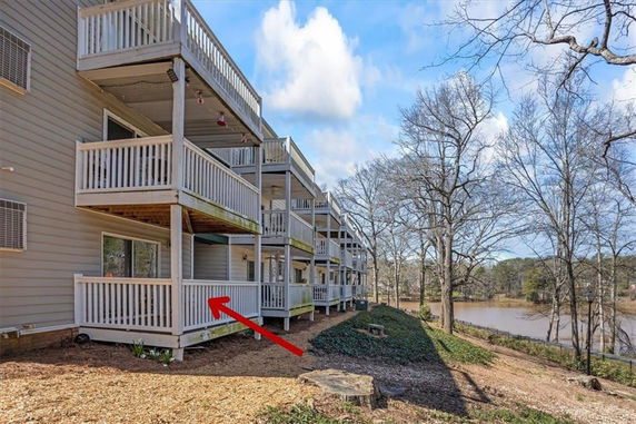 Side view of a multi-level building with balconies facing a lake.