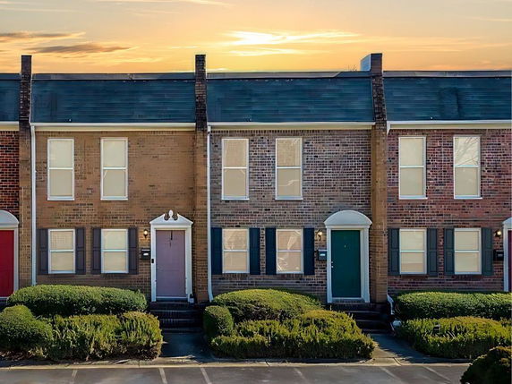 Front view of a row of brick townhouses with uniform design.