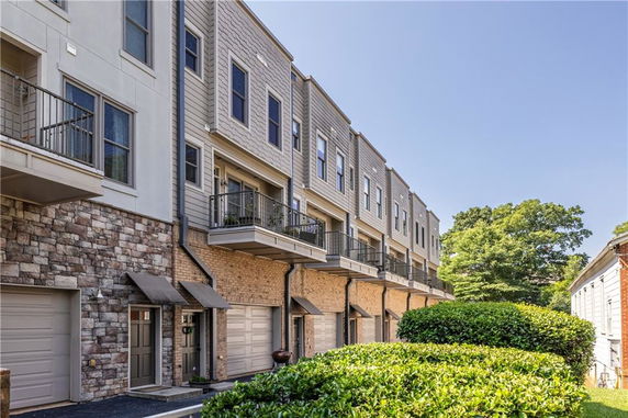 Front view of a multi-story townhouse complex with garages and balconies.