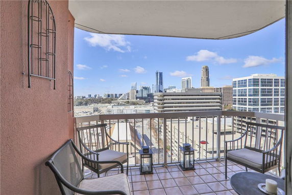 View from a balcony overlooking a cityscape with several tall buildings.