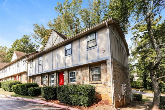 Front view of a two-story townhouse with stone and wood siding.