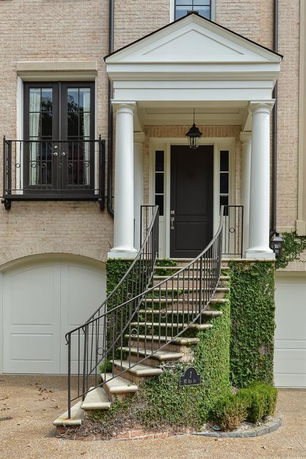 Front view of a house with a grand entrance and curved staircase.