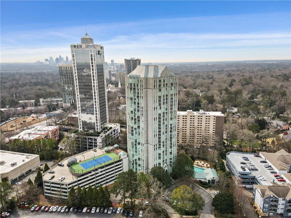 Aerial view of tall residential buildings in a city with surrounding trees and structures.