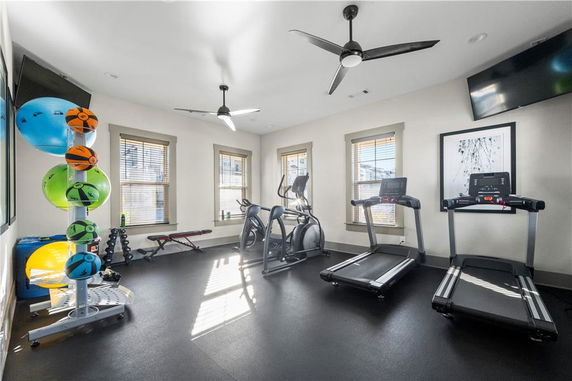Interior view of a fitness room with exercise equipment like treadmills and exercise balls.
