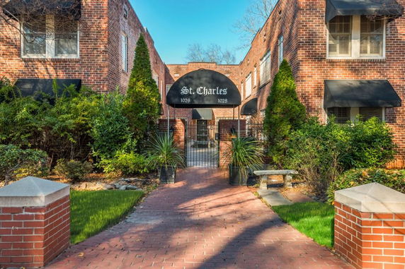 Front view of a brick building with archway and black awnings.
