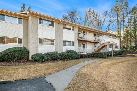 Front view of a two-story apartment building with exterior stairs.