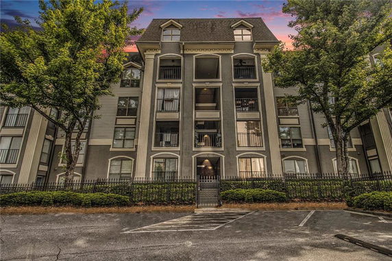 Front view of a multi-story apartment building with balconies.