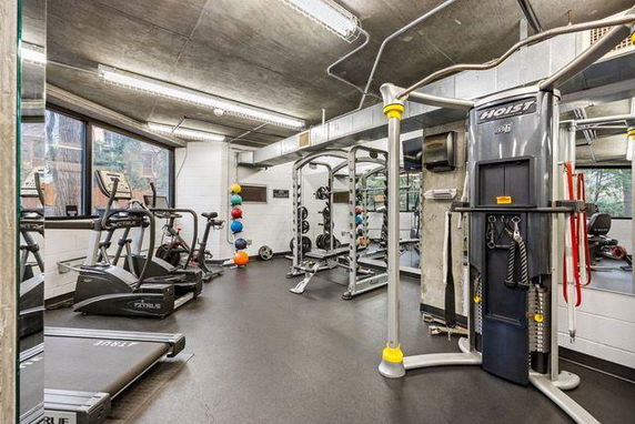 Indoor gym area with exercise equipment, including treadmills, weight machines, and colorful exercise balls.