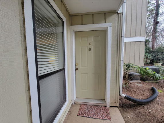 View of a house entrance with a door and adjacent window.