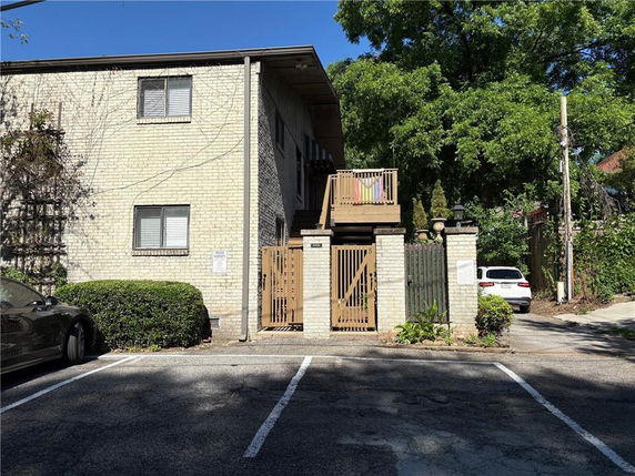 Front view of a two-story building with a gated entrance and parking area.