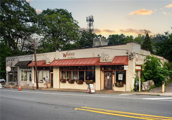 Front view of a single-story commercial building with a sign that says 'Wahoo!'