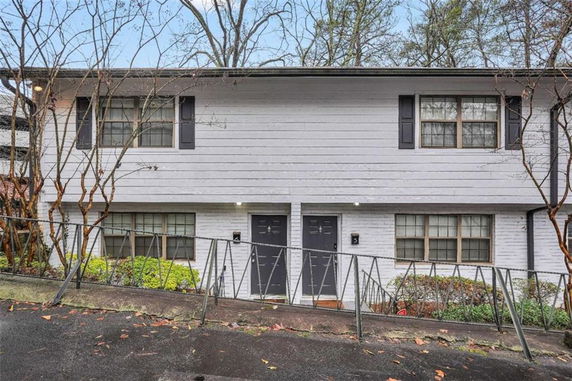 Front view of a two-story house with a sloped driveway.