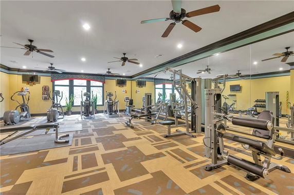 An indoor gym area with various exercise machines and mirrored walls.