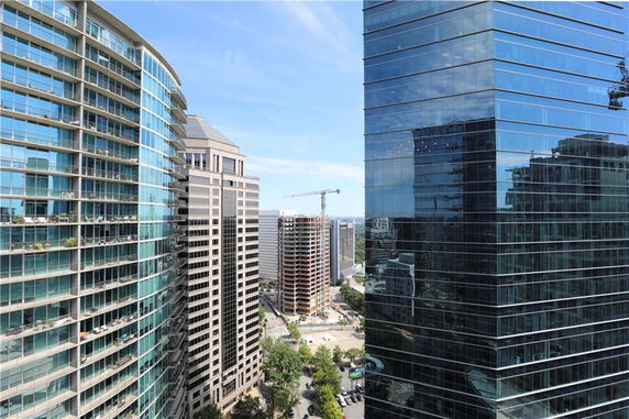 View of tall modern buildings in a cityscape with a clear blue sky.