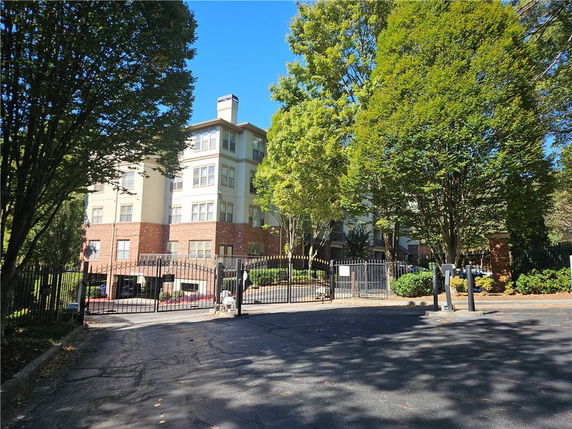 Front view of a multi-story residential building with gated entrance.