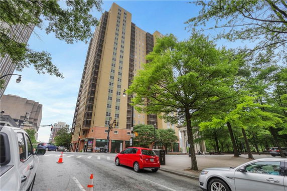 Front view of a tall apartment building on a city street.