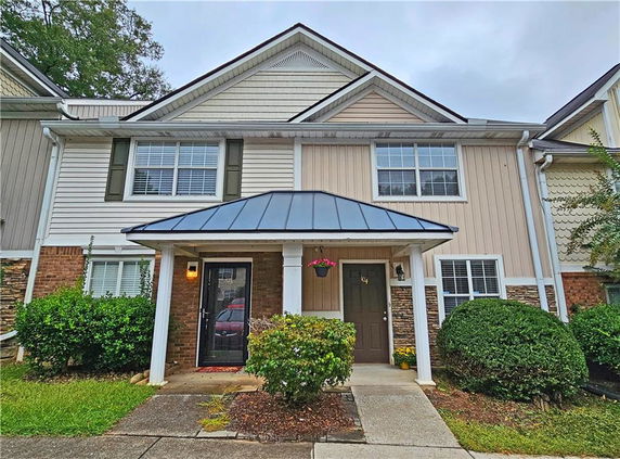 Front view of a two-story townhouse with a covered entryway.