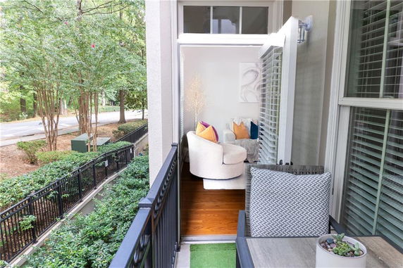 View from a balcony overlooking a street and greenery.