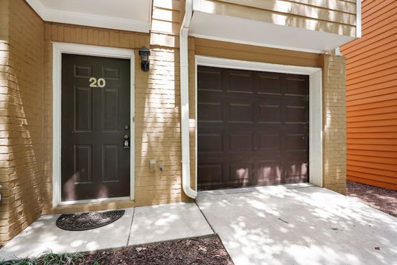 Front view of a building with a dark brown door and garage.