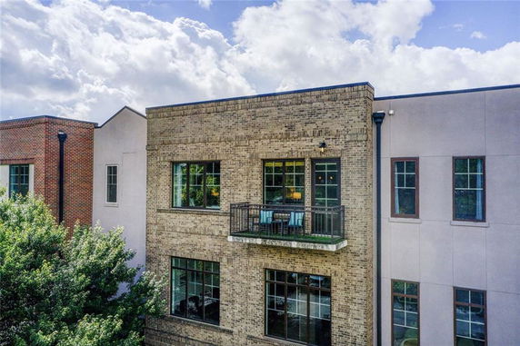 Front view of a multi-story brick building with a small balcony.