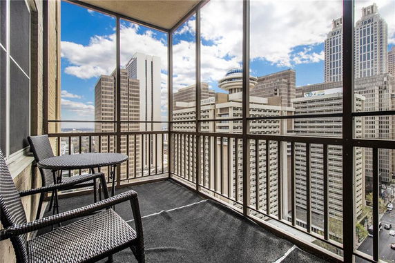 Panoramic view from a balcony overlooking tall skyscrapers.