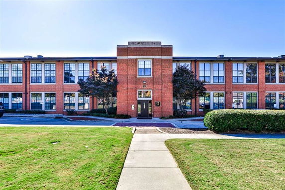 Front view of a two-story brick building with large windows.