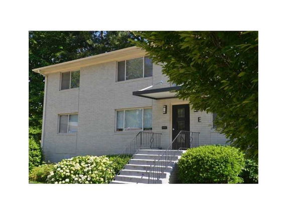 Front view of a two-story house with a staircase leading to the entrance.