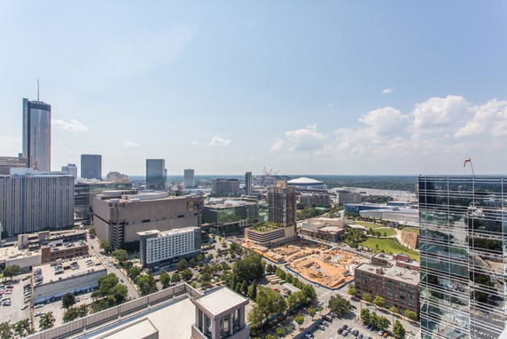 Panoramic view of a city skyline with various buildings and construction areas.